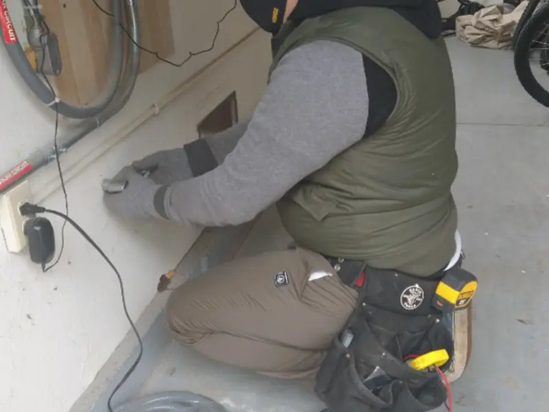 Electrician performing outlet wiring in a Northridge garage